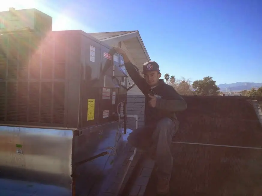 HVAC technician performing Heat Pump Repair on a rooftop unit in East Hemet