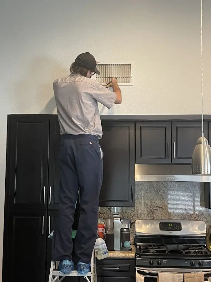 Technician inspecting an air vent during HVAC service in East Hemet